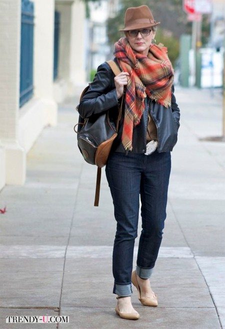 Кожаная куртка, джинсы и клетчатый шарф на женщине 60-ти лет