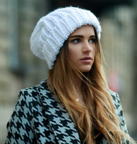 Пальто в сочетании с белой вязаной шапкой на девушке