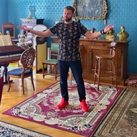 Богдан Юсипчук в темных джинсах, футболке и красных кроссовках