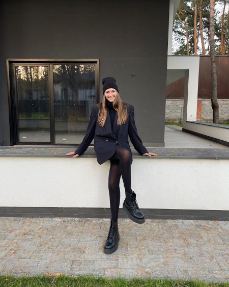 Модель Арина Любителева в черном жакете и черных ботинках